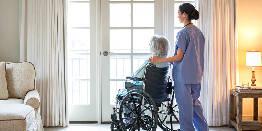 A Helper Carrying a Woman in a Wheelchair One